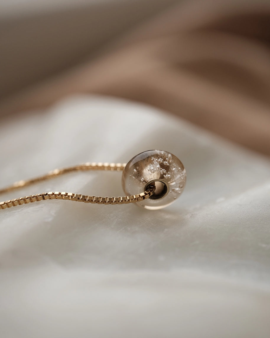 aura ketting met as van een hondje verwerkt, handgemaakte glazen kraal in het goud