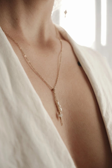 14k gold memorial necklace with a pendant on a person wearing a white top.