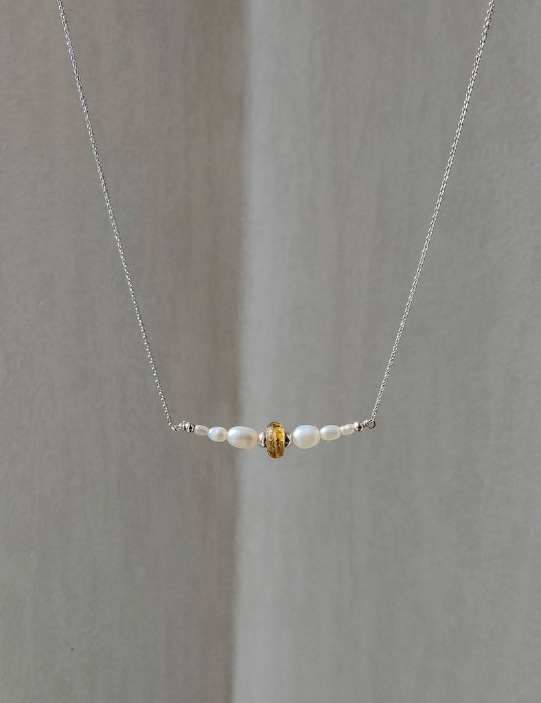 Necklace with memorial beads on a gray background.