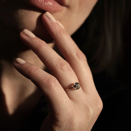 Handgemaakte gouden gedenk ring waarin as, haar of een andere dierbare herinnering zorgvuldig in glas wordt verwerkt geschoten op hand van model.