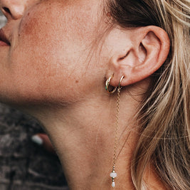 as oorbel handgemaakt in 14k goud te zien op jonge vrouw