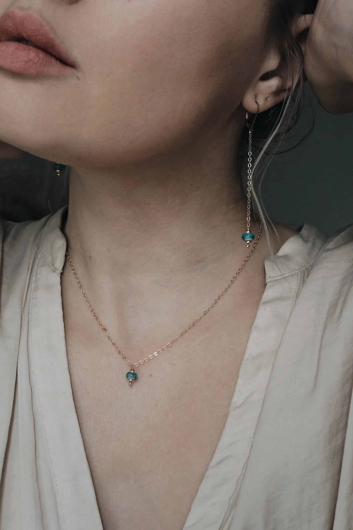 as of haar verwerkt in glazen bedel oorbel gedragen op model