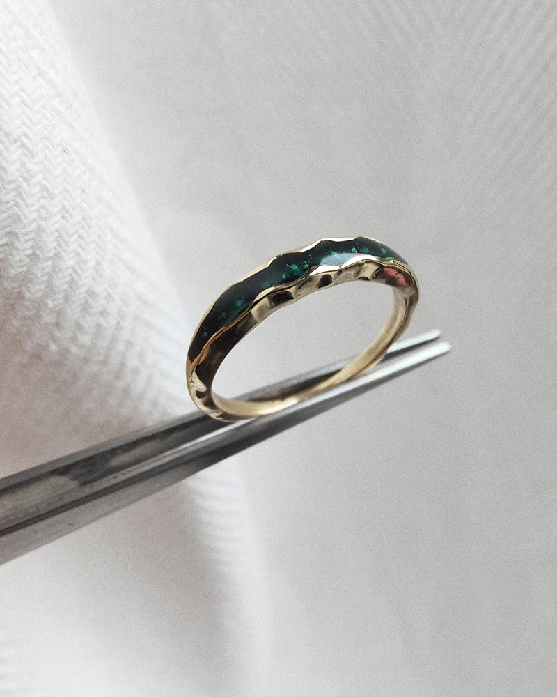 Gold memorial cremation ring with a textured design on a white background.