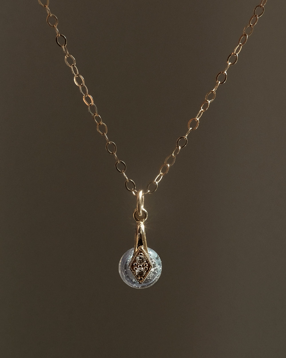 Gouden handgemaakt gedenksieraad met as of haar verwerkt in glas