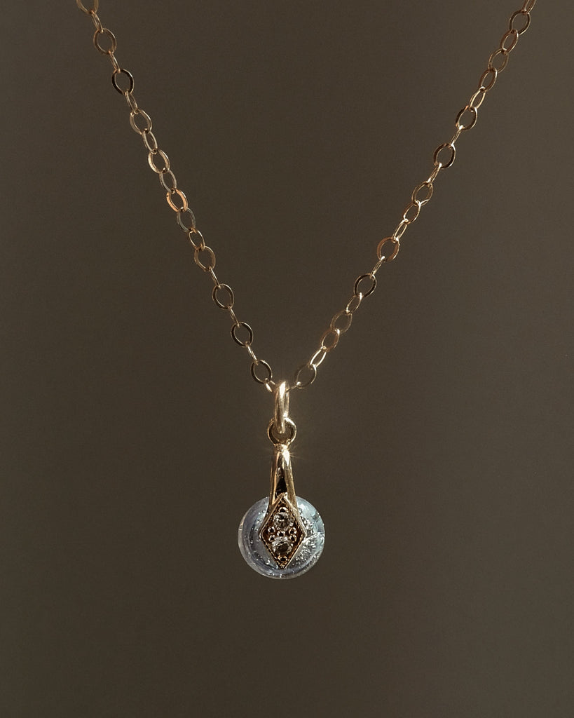 Gold memorial necklace with a cremation pendant on a dark background