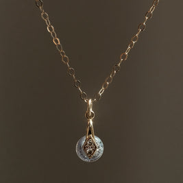 Gouden handgemaakt gedenksieraad met as of haar verwerkt in glas