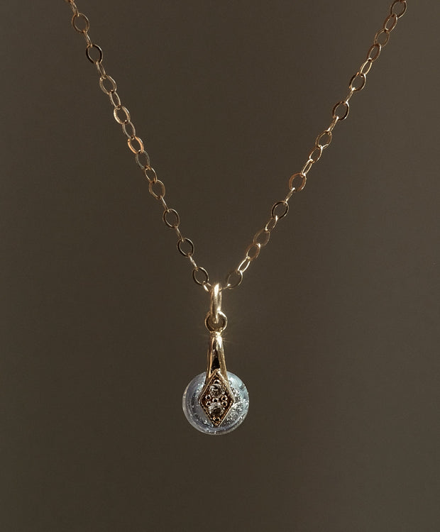 Gouden handgemaakt gedenksieraad met as of haar verwerkt in glas