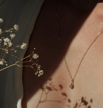 Gouden of zilveren handgemaakte gedenksieraad met as of haar verwerkt in glas