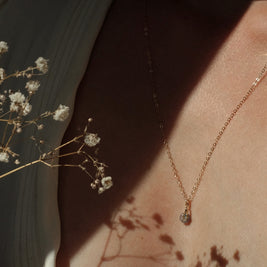 Gouden of zilveren handgemaakte gedenksieraad met as of haar verwerkt in glas