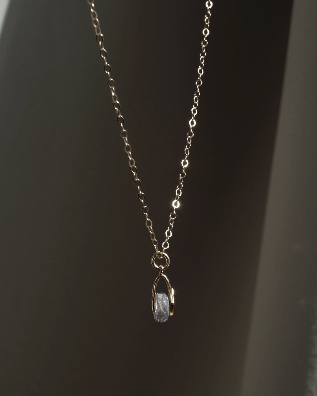 Gouden of zilveren handgemaakte gedenksieraad met as of haar verwerkt in glas