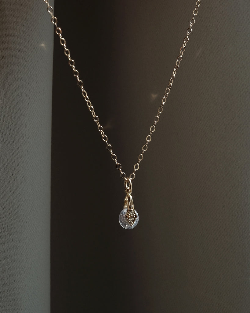 Necklace with a teardrop-shaped keepsake pendant on a dark background