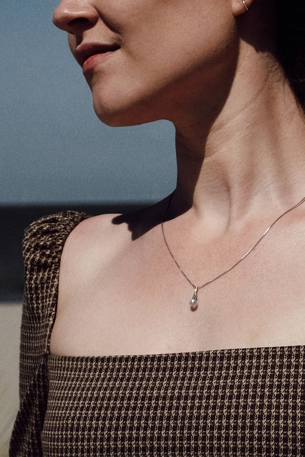 crematie sieraad ketting minimalistisch gedragen op model aan de zee