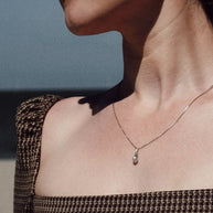 crematie sieraad ketting minimalistisch gedragen op model aan de zee