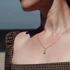 crematie sieraad ketting minimalistisch gedragen op model aan de zee