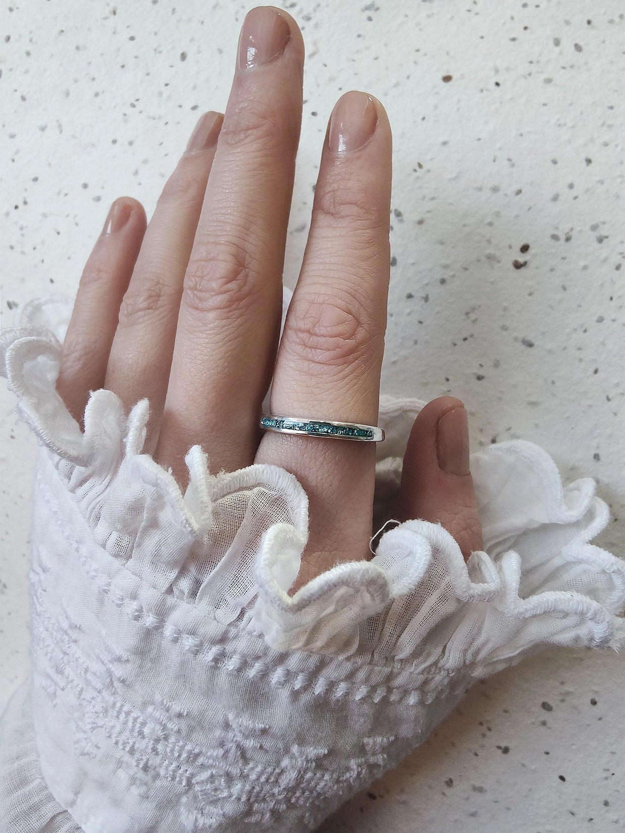 handgemaakte gedenkring met as in zilver aan hand