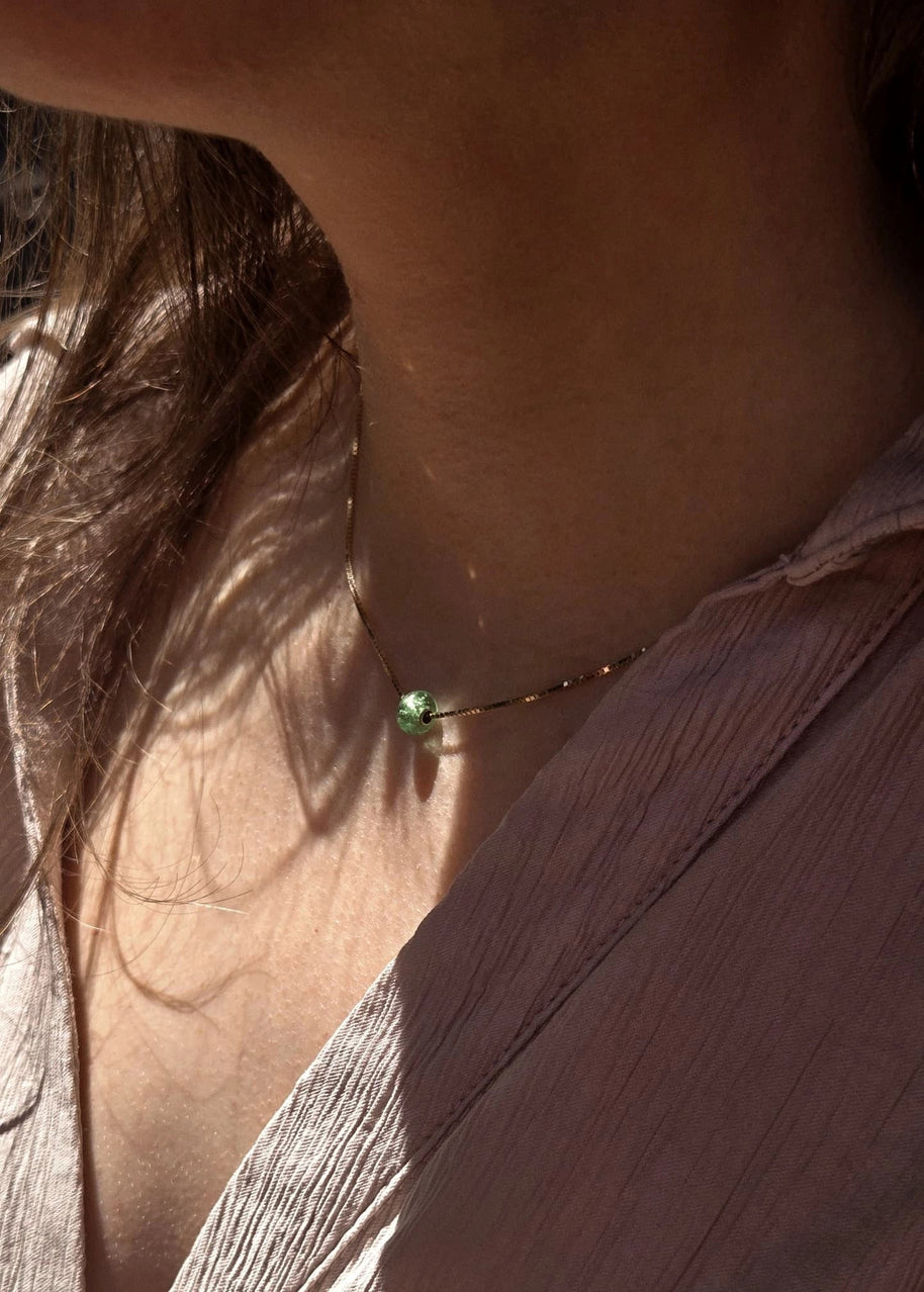 closeup van een vrouw die een askettnig draagt met de as van haar verloren moeder