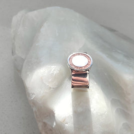 Silver ring with a white stone on a light gray background