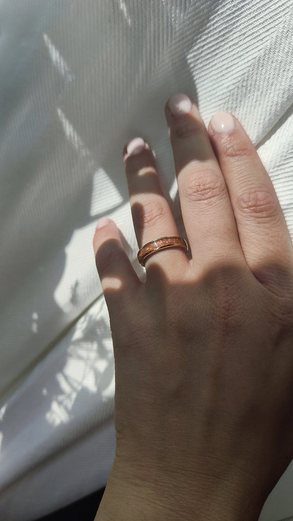 Hand with a memorial ring on a white background.