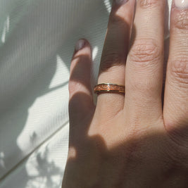 Hand wearing a cremation ring with a white background