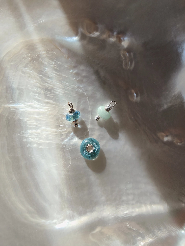 Small blue memorial beads on a white shell made for Teske de Schepper and her family.