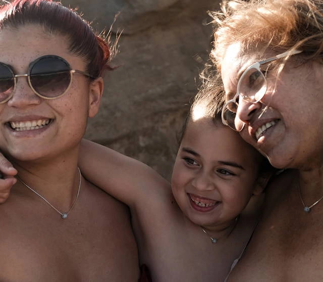 family wearing memorial necklaces.