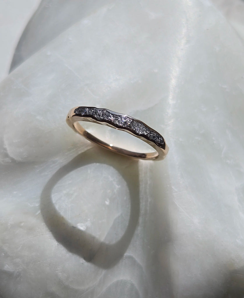 Memorial cremation ring with silver gemstones on a white background.