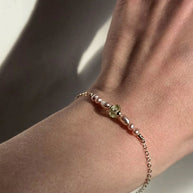 prachtige handgemaakte armband met groene bedel van glas en zacht roze parels in het gold filled