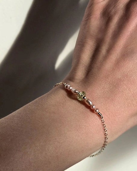 prachtige handgemaakte armband met groene bedel van glas en zacht roze parels in het gold filled